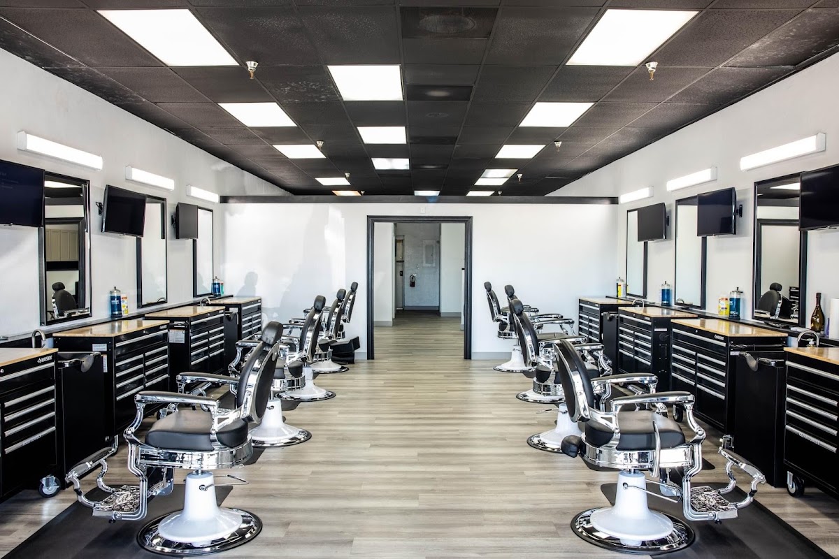 Bright, modern barbershop interior with chrome chairs and black stations