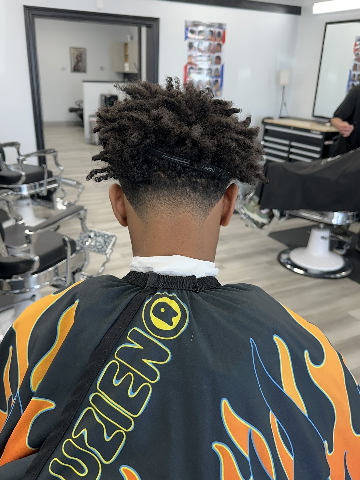 Textured curly twist fade viewed from behind in the shop